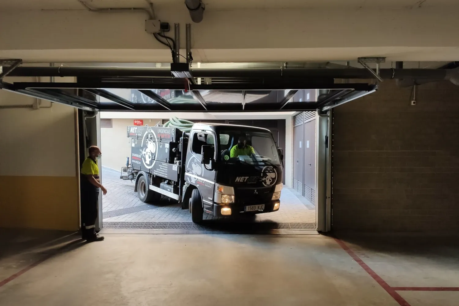 En la imagen se muestra un camión de netjet, entrando en lo que parece un parking. Se puede destacar el buen estado del camión. Este camión puede favorecer una buena gestión de problemas a la hora rehabilitar cañerías en infinidad de situaciones.